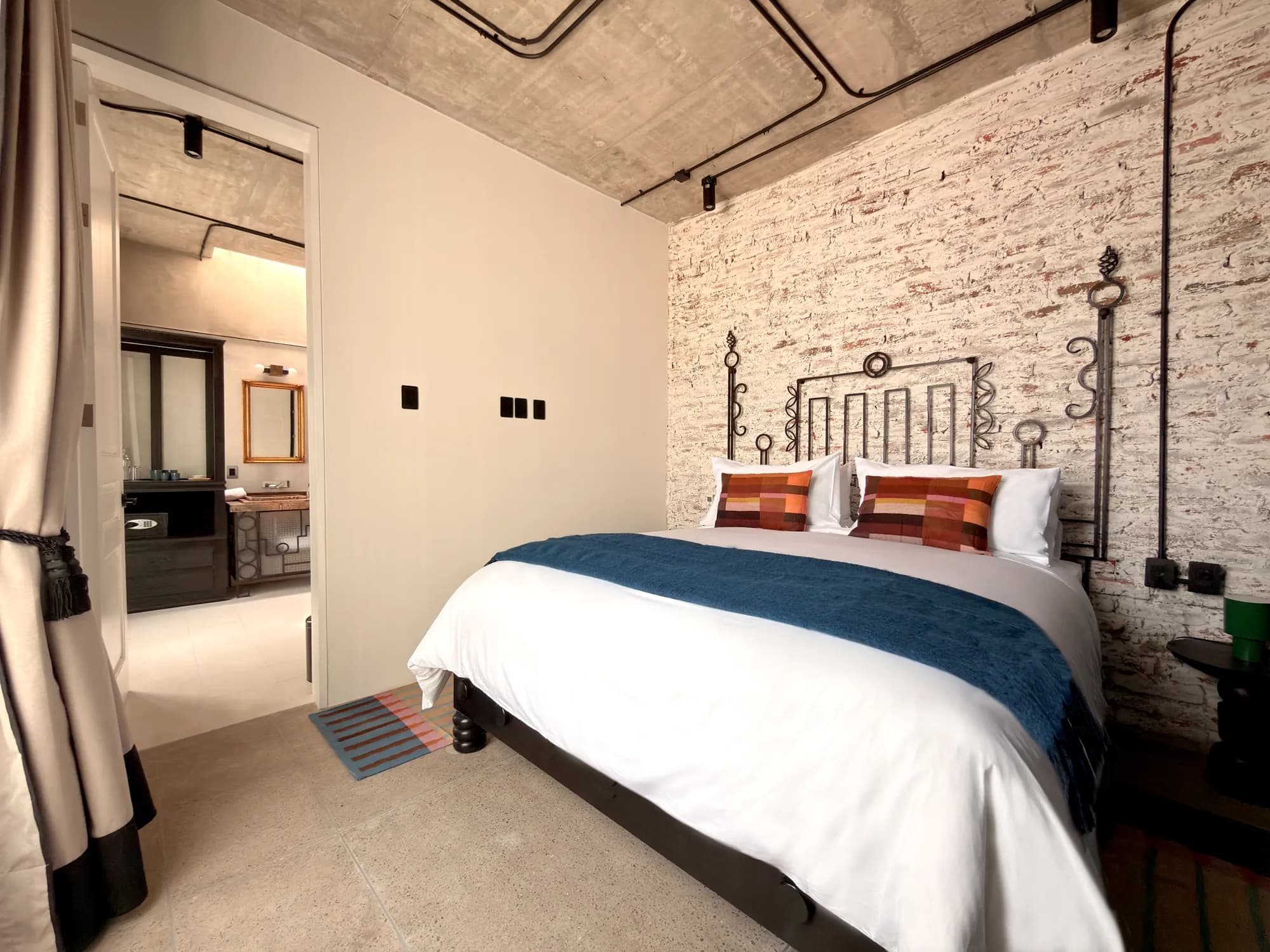 The King bed seen from the entrance, with the bathroom at the back through the open door